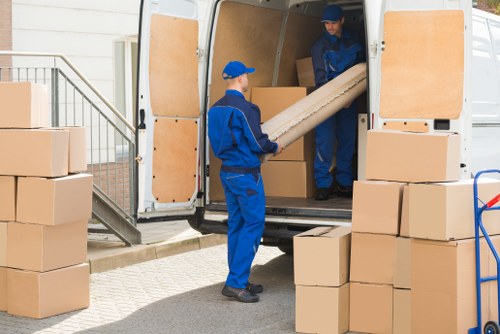 Professional team handling piano removals in Brompton with protective wrapping